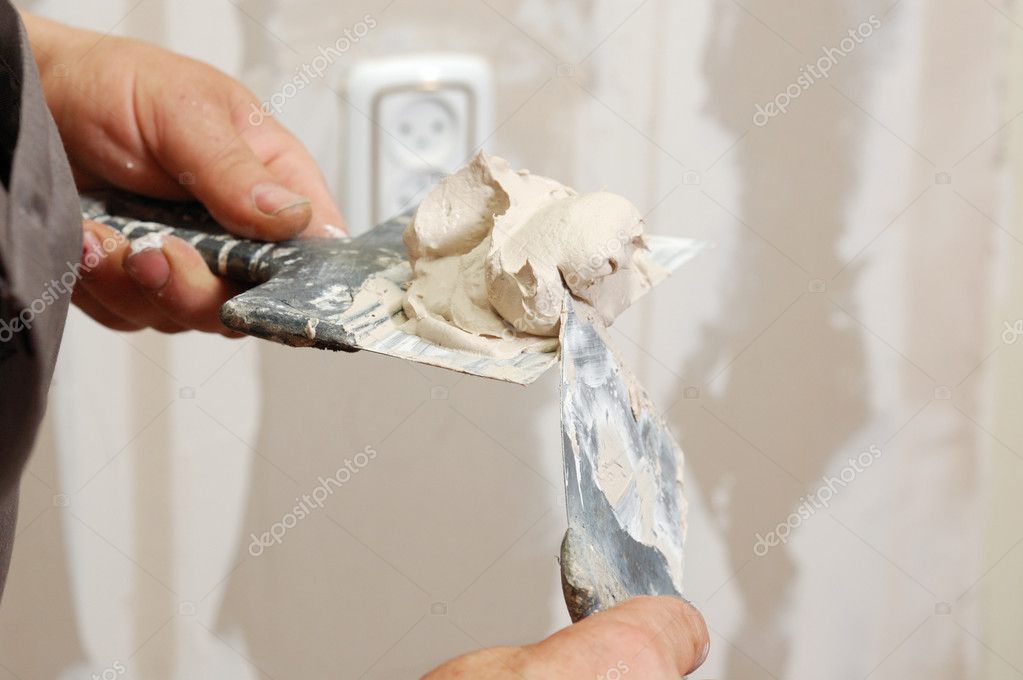 Handyman repairing damaged drywall in a home