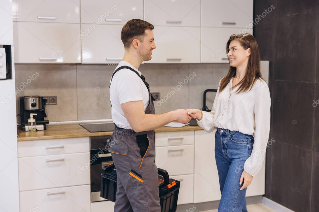 Handyman shaking hands with a homeowner after finishing a job