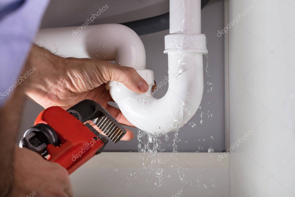 Under-sink plumbing with active leak and corroded fittings